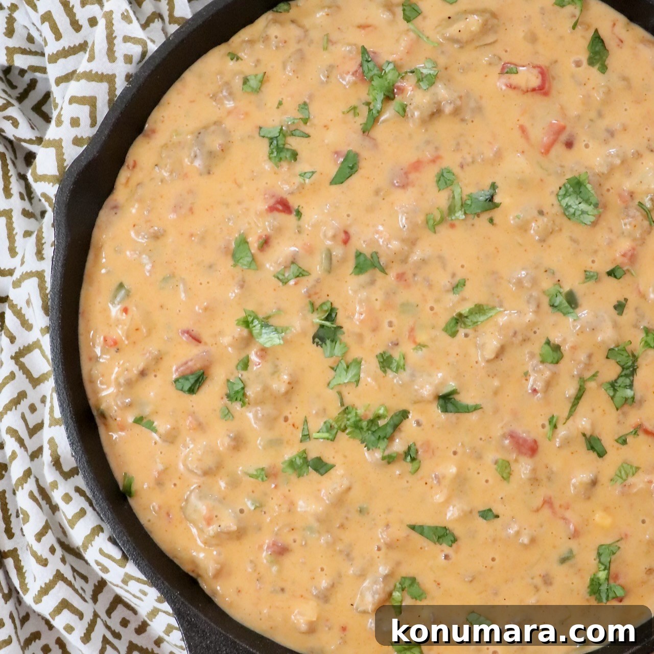 smoked queso dip in a skillet topped with fresh cilantro