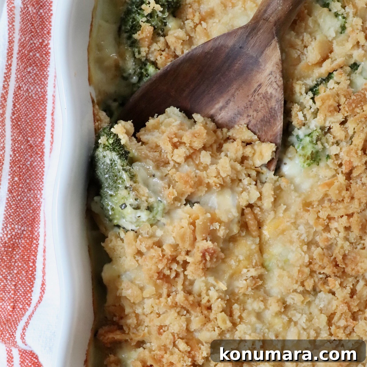 baked casserole with a cracker topping in a baking dish with a serving spoon