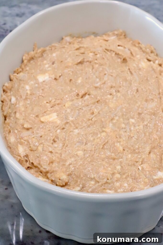 Spicy Nashville Hot Chicken Dip Recipe 6 A white ceramic dish filled with unbaked creamy chicken dip