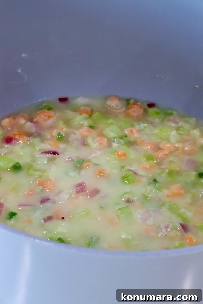 diced vegetables in a roux mixture in a large pot