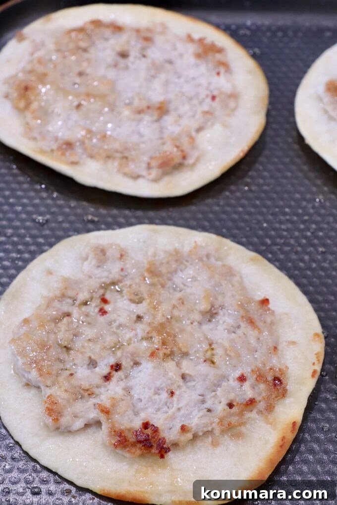 smash tacos on a griddle with the meat facing up