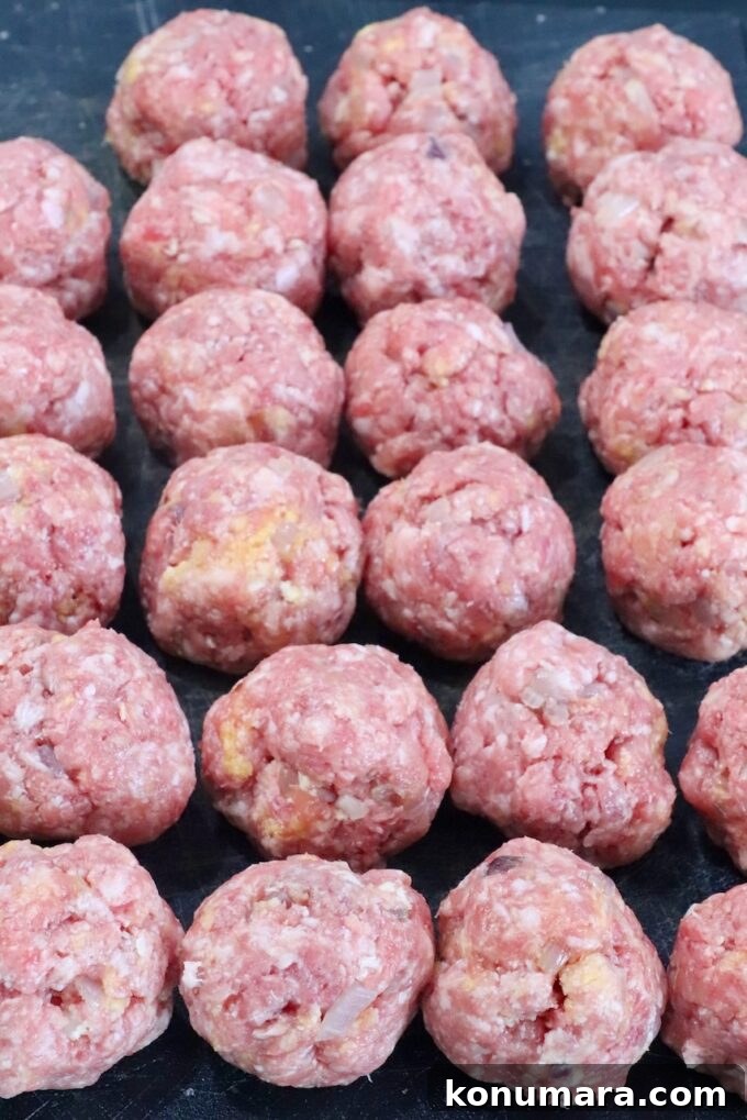 raw meatballs on a dark cutting board