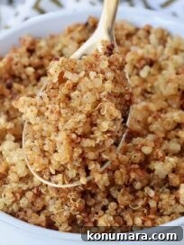 crispy quinoa in a gold spoon lifted out of a bowl of crispy quinoa