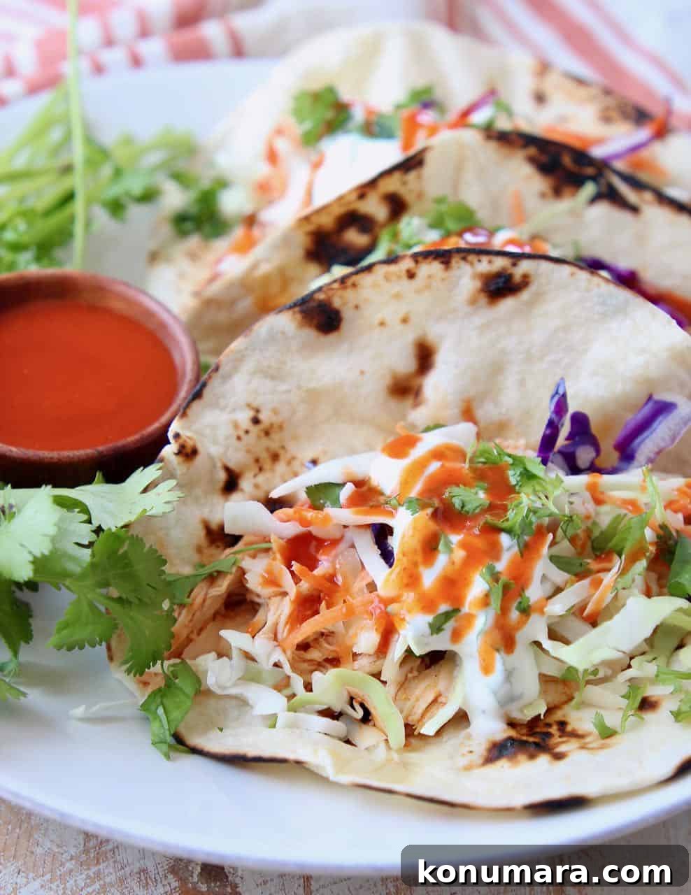 Tacos on plate with slaw and buffalo sauce