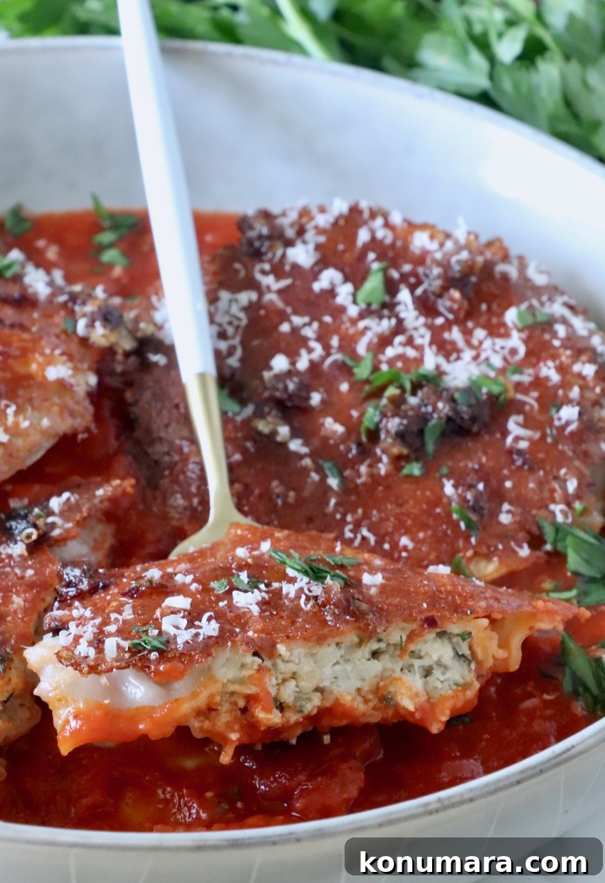 chicken ravioli cut in half on a fork, in a bowl with marinara sauce