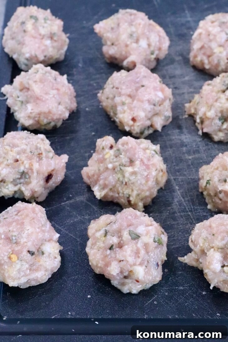 raw chicken meatballs on a cutting board