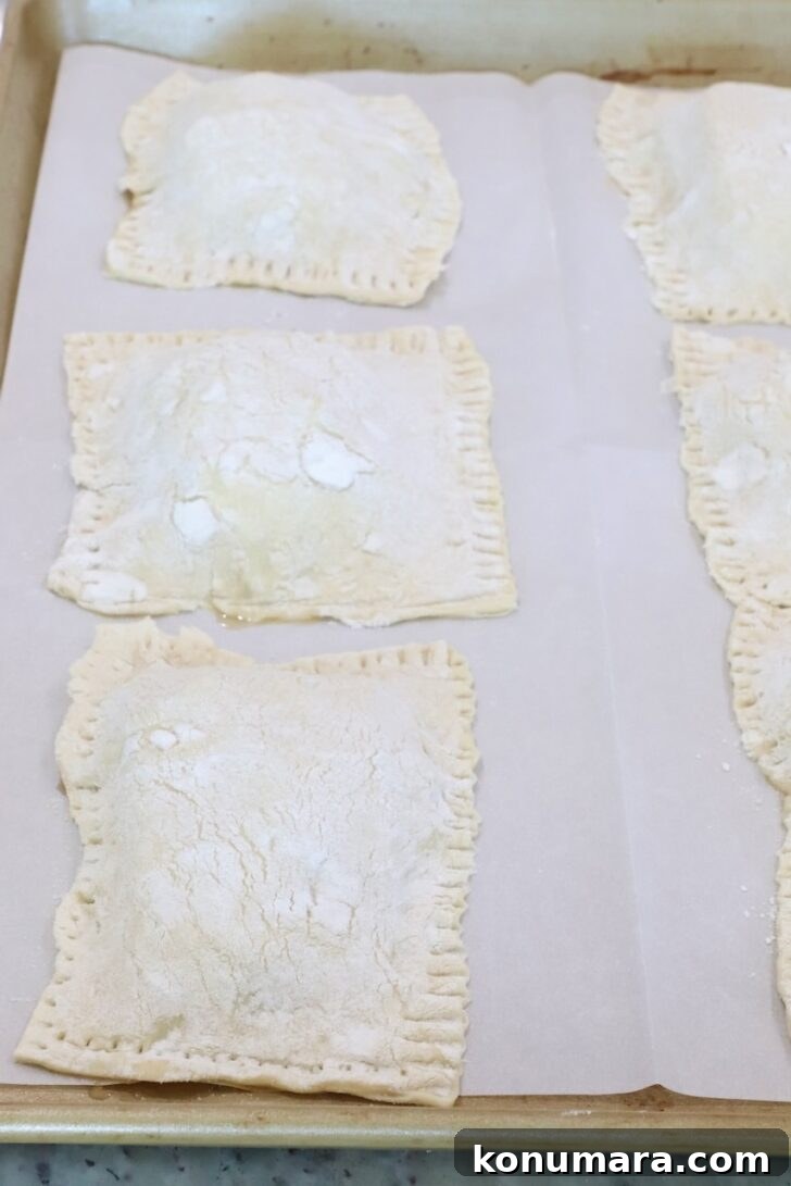 unbaked tarts on a parchment-lined baking sheet