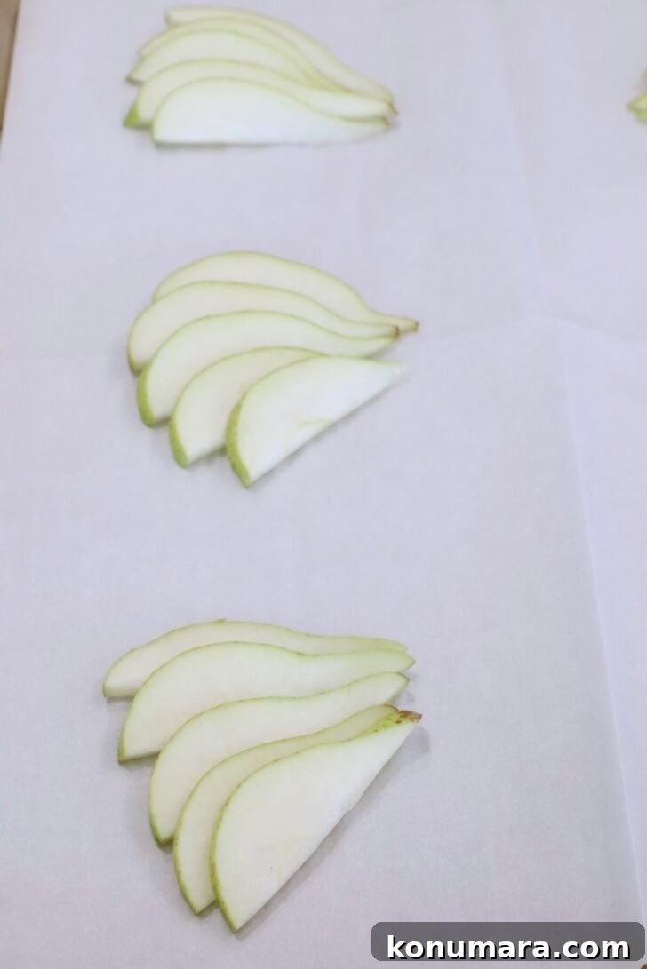 sliced pears on a sheet of parchment paper on a baking sheet