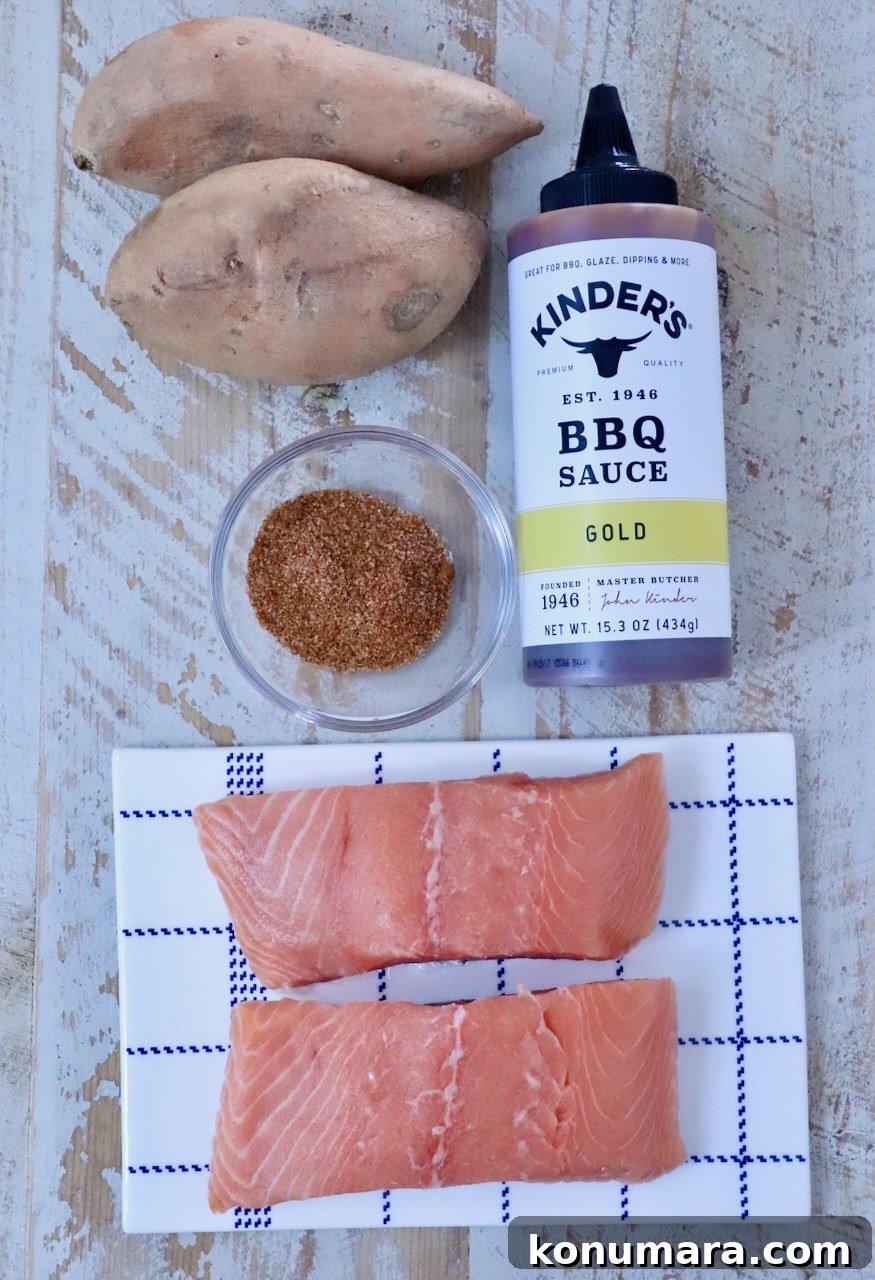 BBQ Salmon with Maple Glazed Sweet Potatoes 5 Raw salmon fillets on a checkered plate, accompanied by sweet potatoes, BBQ sauce, and a bowl of spices on a rustic wooden surface.