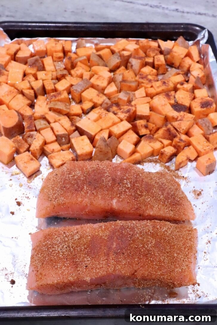 BBQ Salmon with Maple Glazed Sweet Potatoes 6 diced seasoned sweet potatoes on a foil lined baking sheet with two pieces of seasoned salmon filets