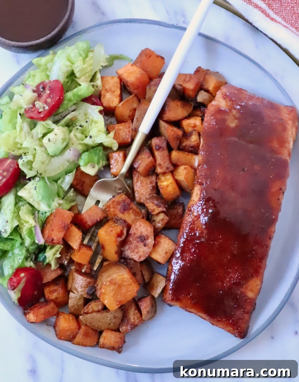 BBQ Salmon with Maple Glazed Sweet Potatoes 8 bbq glazed salmon on a plate with roasted sweet potatoes, a side salad, and a fork