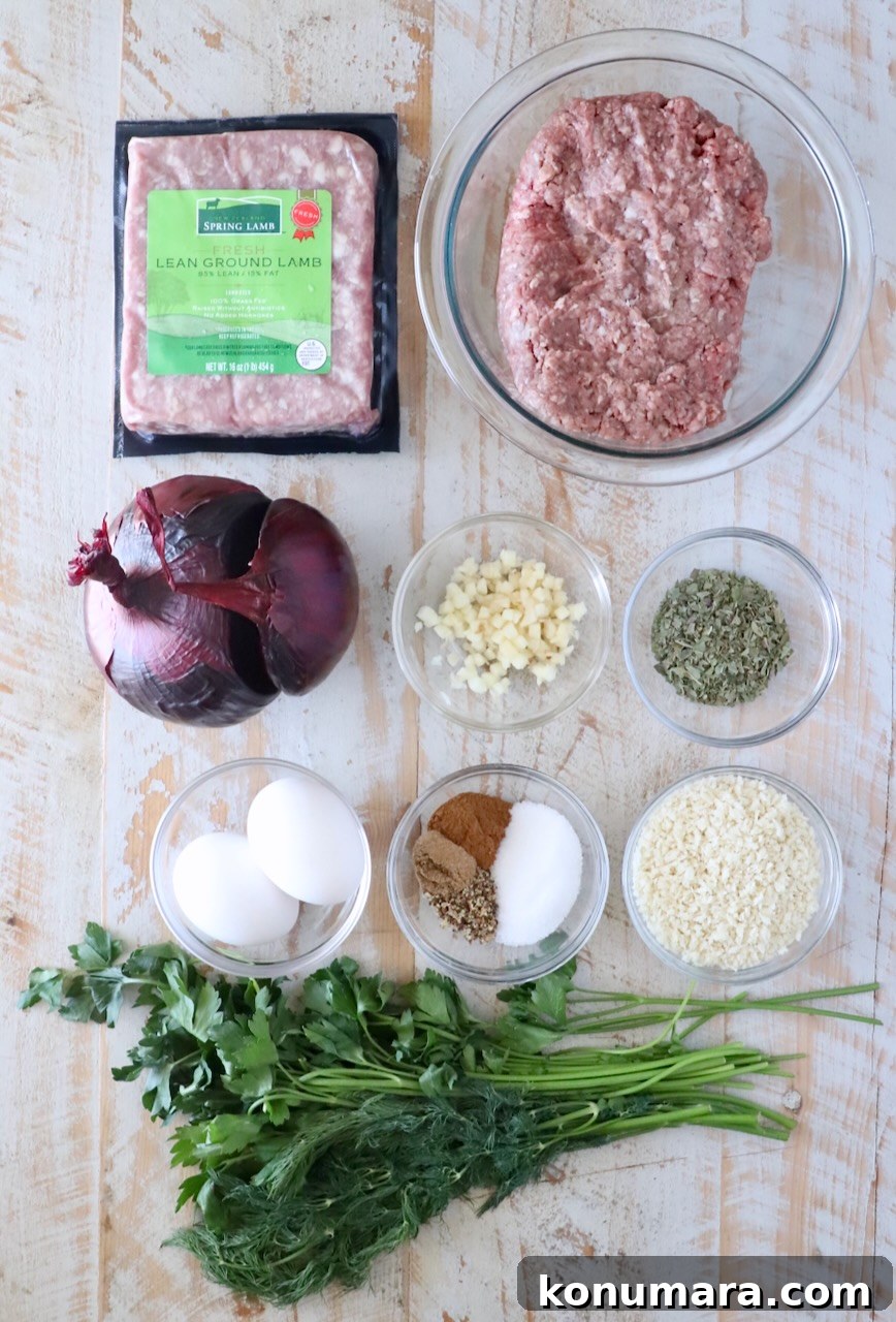 Gyro-Style Meatballs with Tzatziki Sauce 5 Ingredients for gyro meatballs on wooden surface: packaged lean ground lamb, ground beef in a glass bowl, chopped garlic, dry herbs, eggs, spices, panko breadcrumbs, red onion, fresh parsley, and dill.