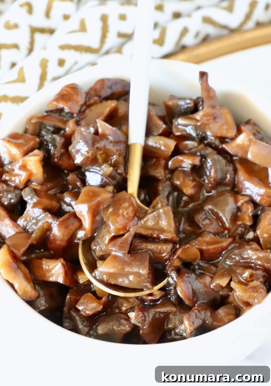 mushroom jam in a white bowl with a gold and white spoon