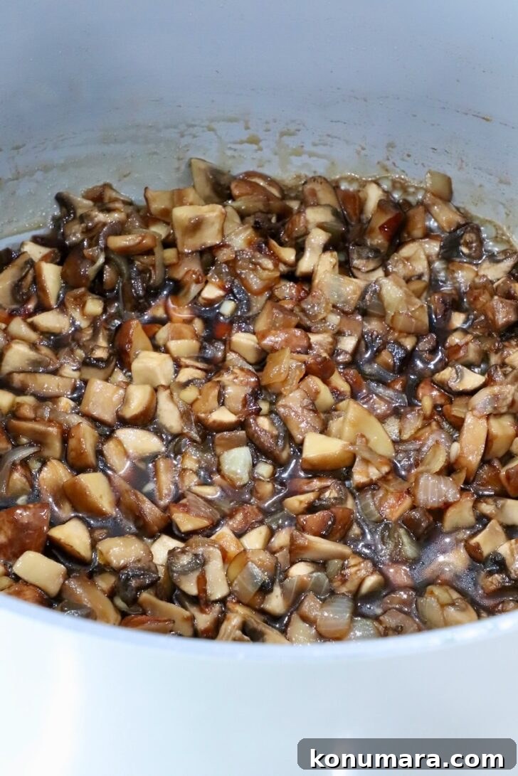 cooked mushrooms in a pot with maple syrup, brown sugar, and vinegar
