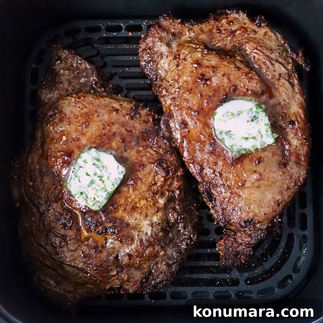 Ribeye steaks in air fryer topped with herb butter