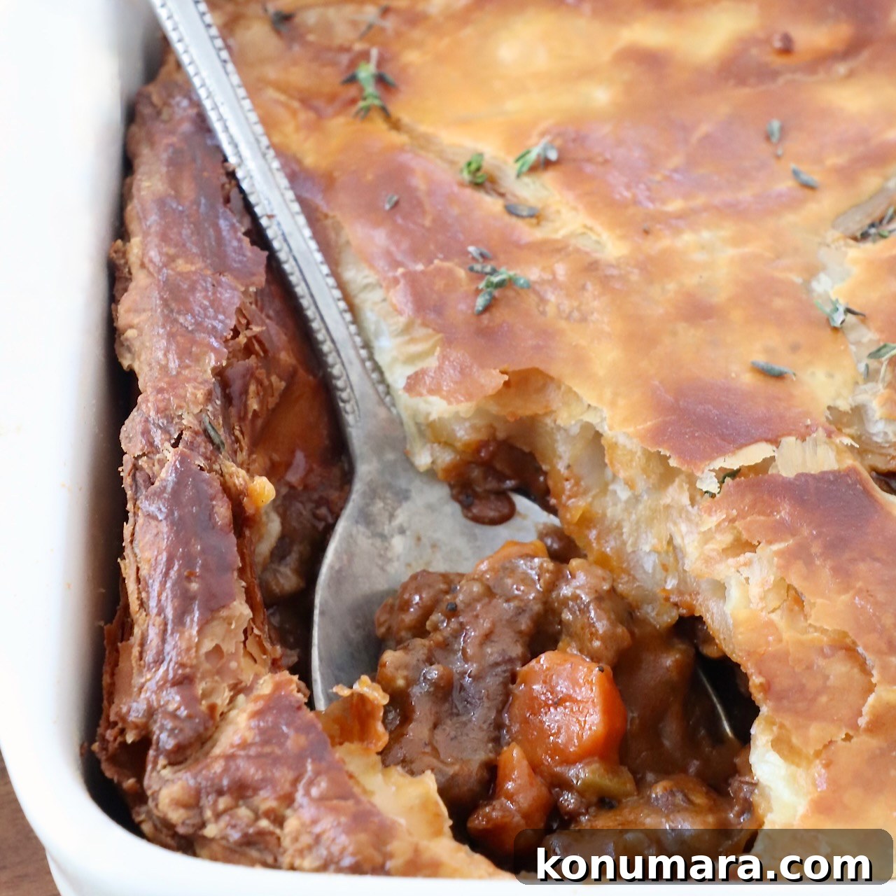 Beef pot pie with a serving spoon in the crust