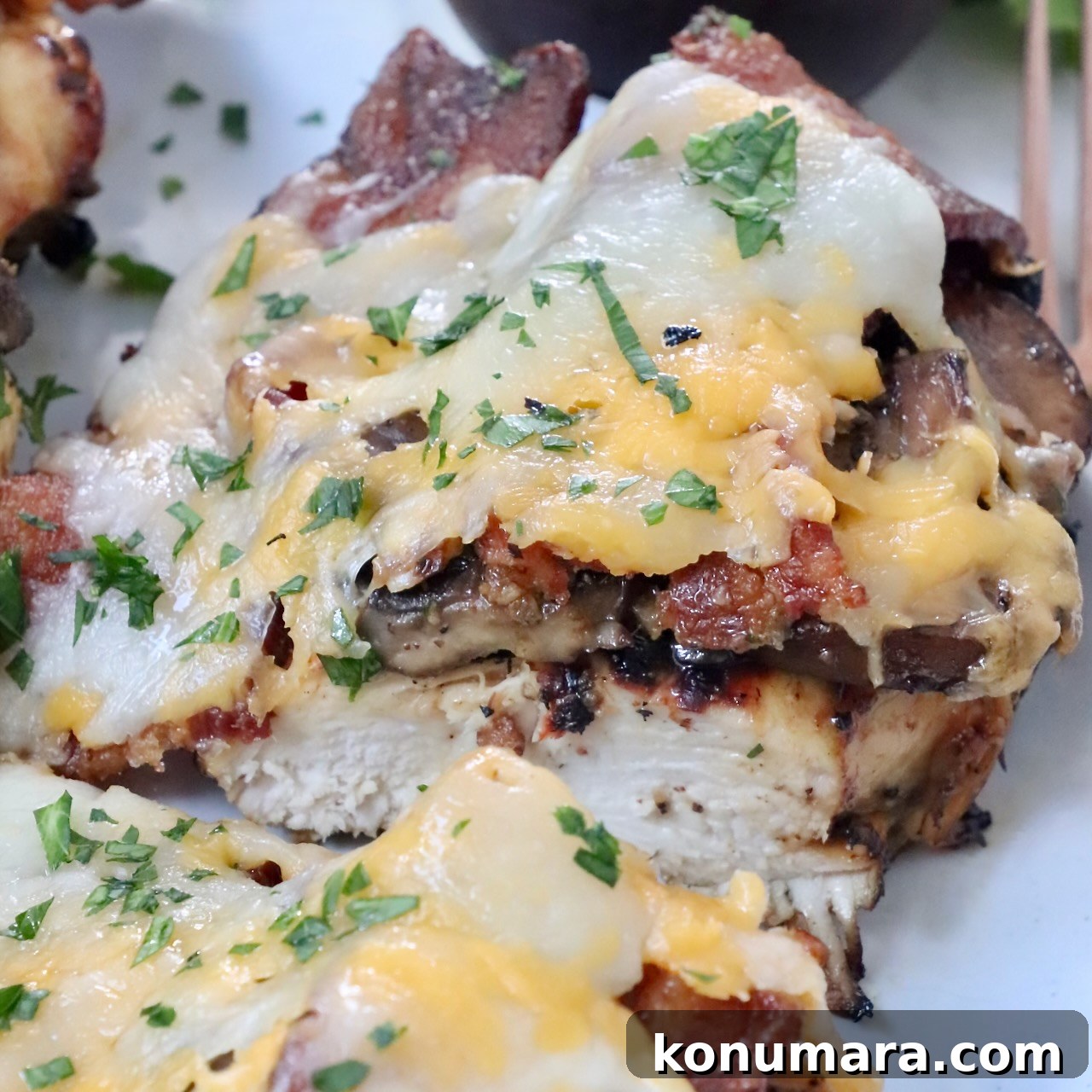 Grilled chicken topped with bacon and cheese, sliced in half