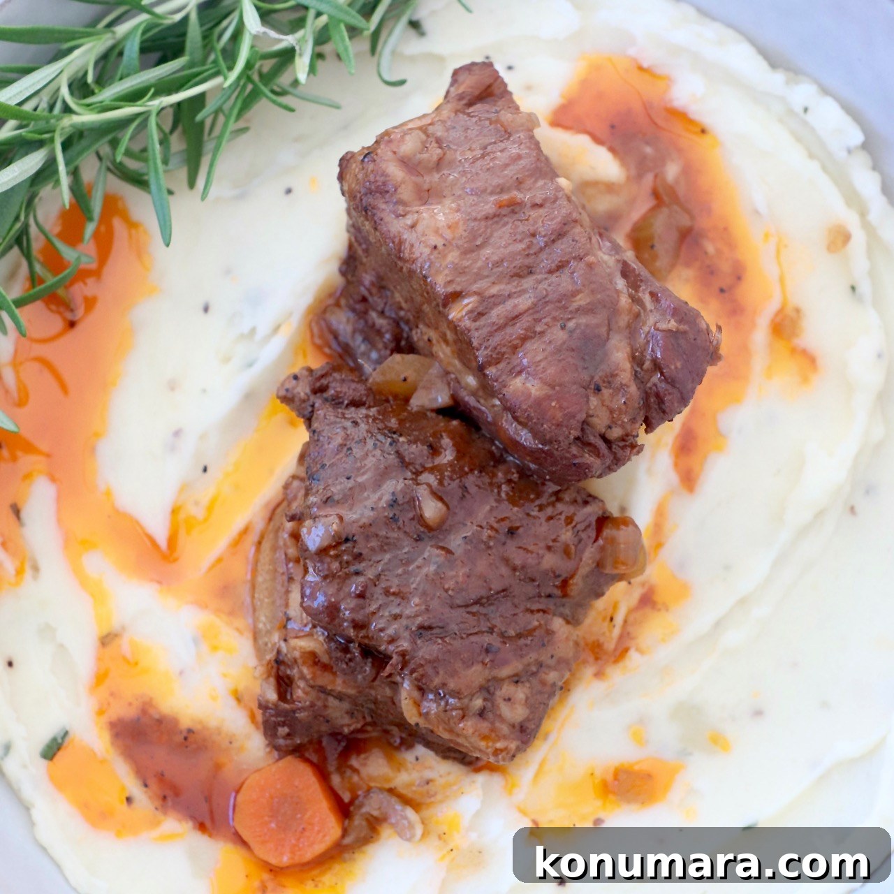 Braised short ribs in bowl with mashed potatoes and rosemary
