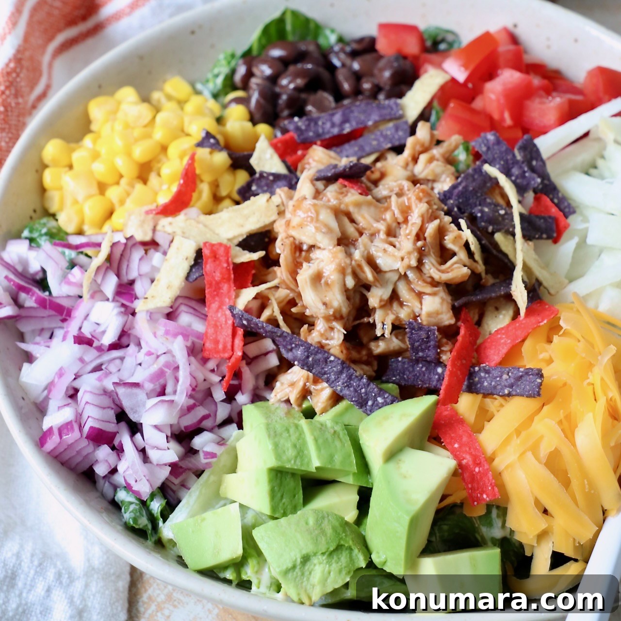 BBQ chicken salad in a bowl topped with shredded chicken