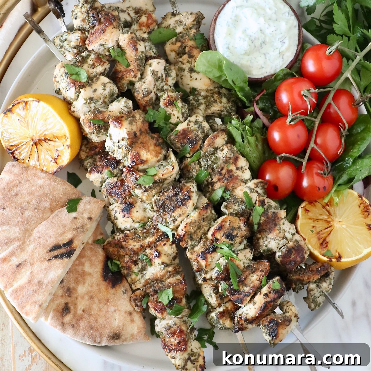 Grilled chicken souvlaki with pita, tzatziki, tomatoes, and lemon