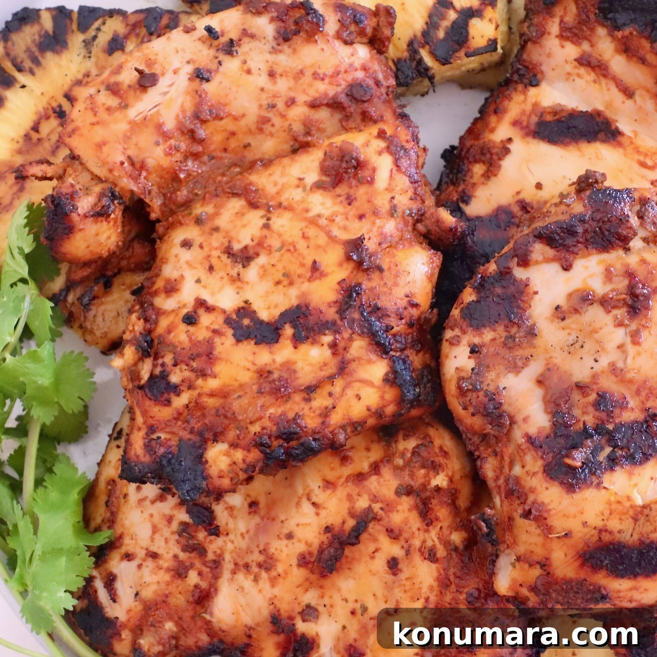 Grilled chicken thighs with char marks garnished with cilantro
