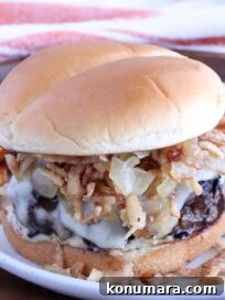 french onion burger on a plate topped with crispy onions and caramelized onions