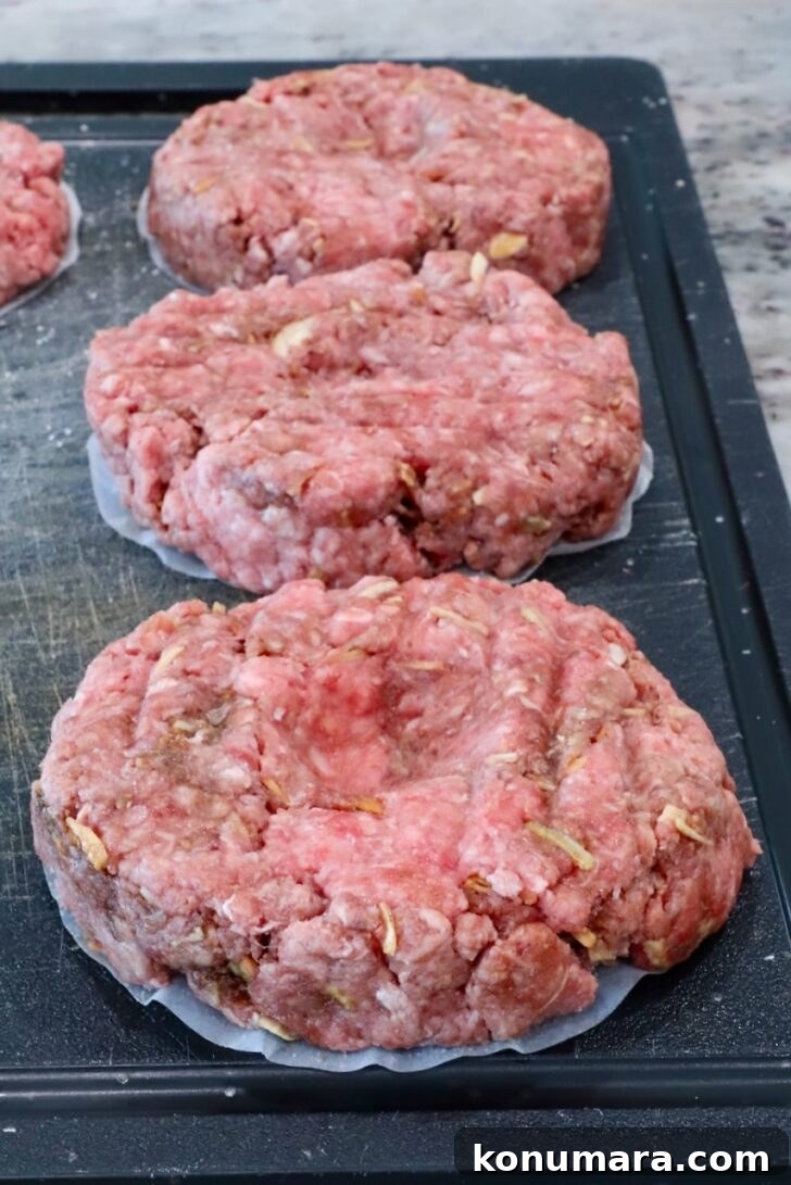 raw burger patties on a cutting board