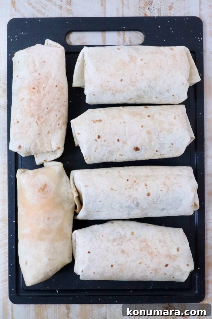 Vegetarian Cheesy Bean and Rice Burrito Recipe 13 six prepared burritos on a cutting board