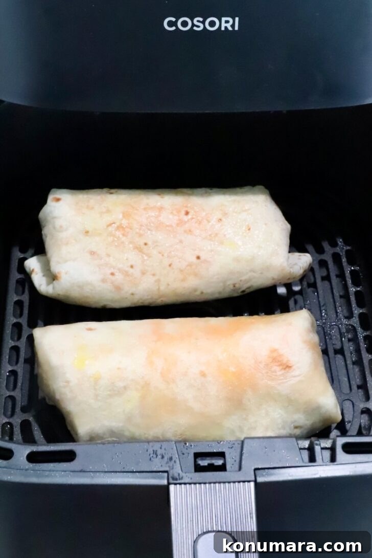 Vegetarian Cheesy Bean and Rice Burrito Recipe 14 two burritos in an air fryer basket