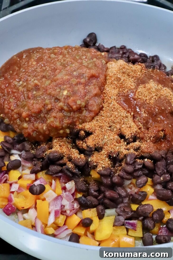 Vegetarian Cheesy Bean and Rice Burrito Recipe 6 diced bell pepper, onion, black beans, salsa, and taco seasoning in a skillet