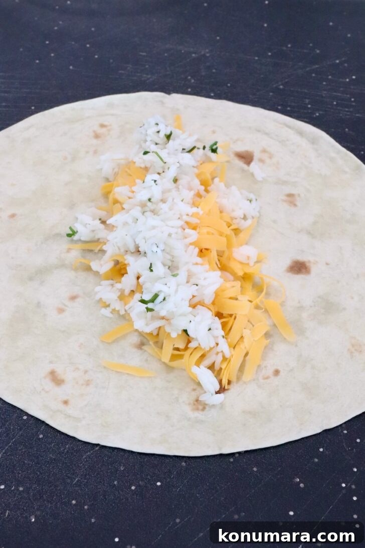 Vegetarian Cheesy Bean and Rice Burrito Recipe 9 shredded cheddar cheese and cilantro lime rice in the middle of a tortilla