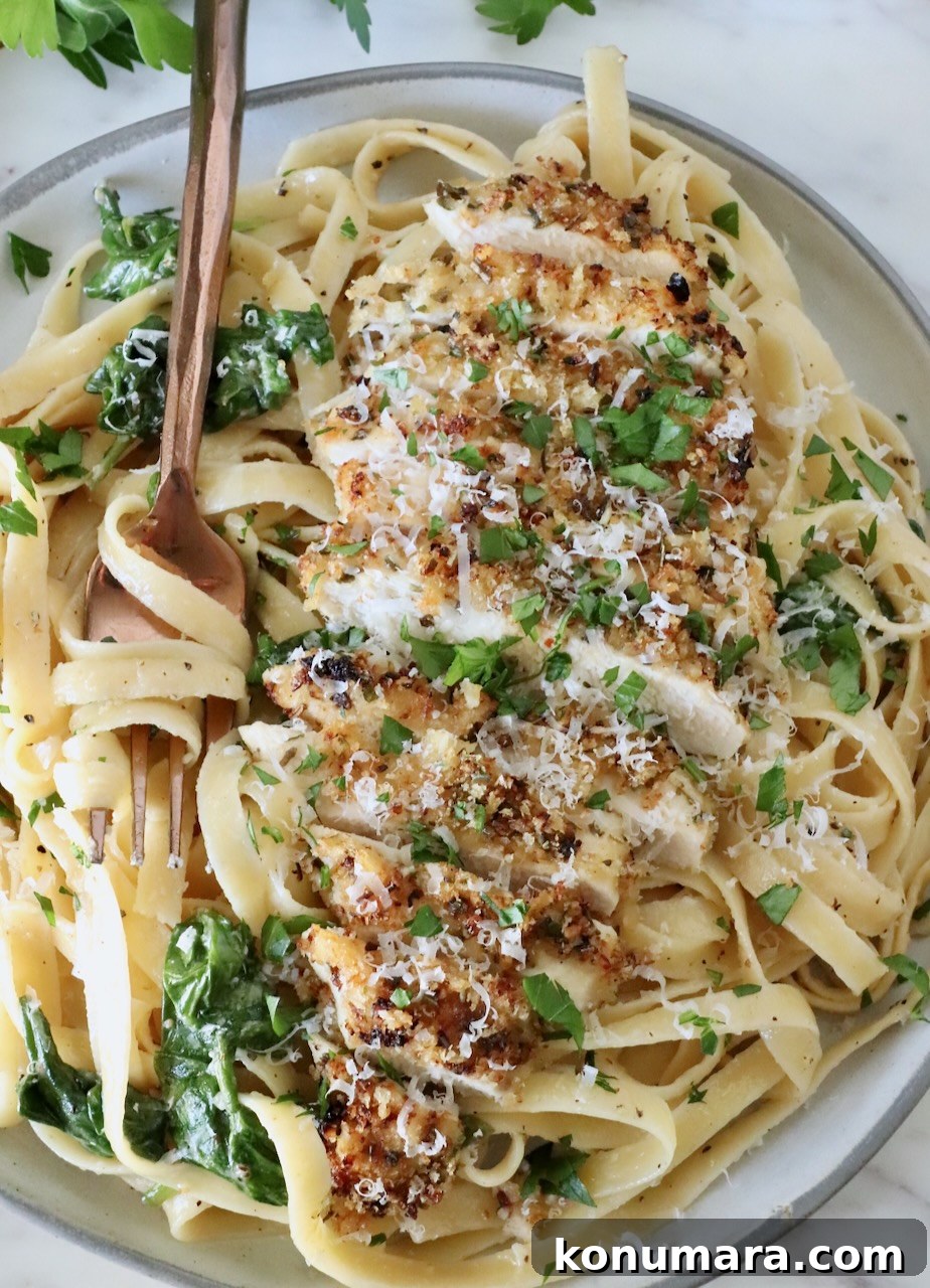 Creamy Chicken Caesar Pasta with Parmesan and Croutons 12 chicken caesar pasta in a bowl with a fork, topped with fresh parsley and parmesan cheese