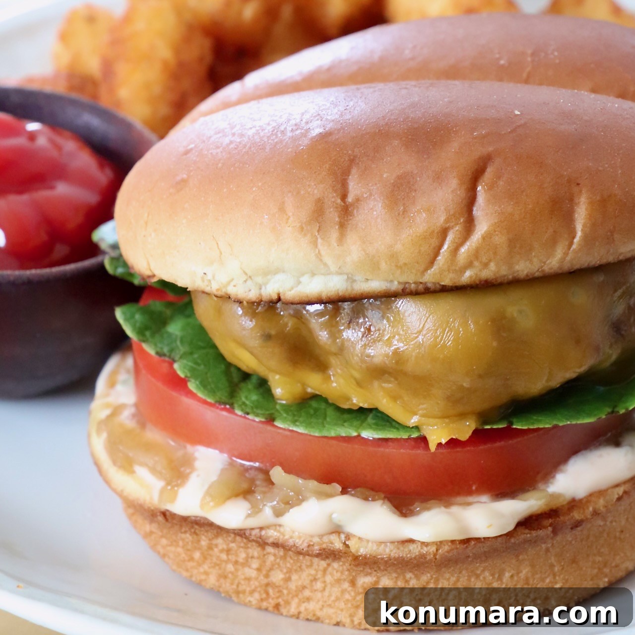 cheeseburger on plate with a side bowl of ketchup