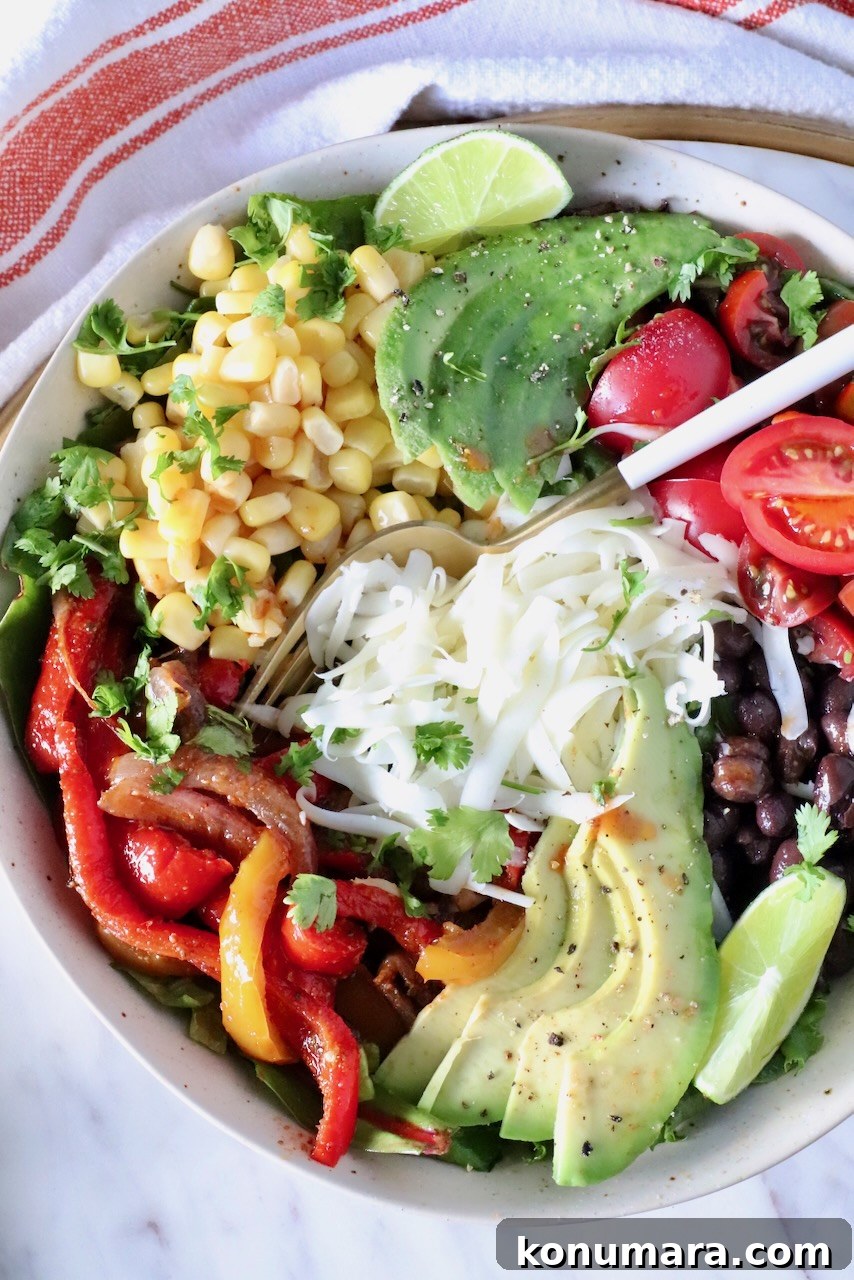 Zesty Chipotle Salad with Avocado, Corn and Lime 2 chipotle salad in a bowl topped with fajita veggies, cheese, avocado, corn, and tomatoes