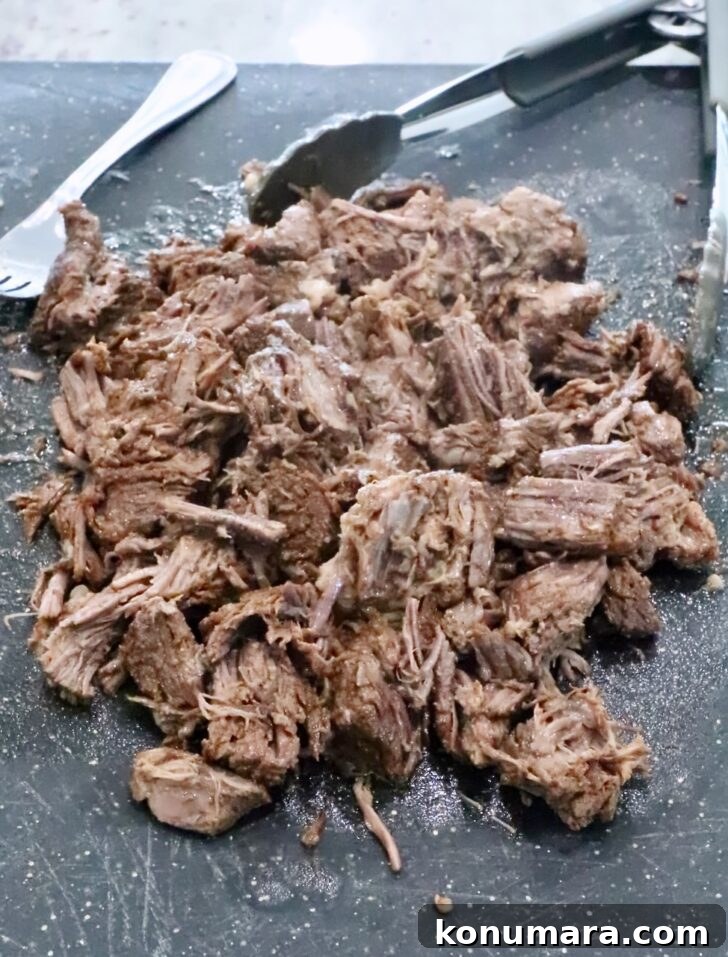 shredded beef on a cutting board
