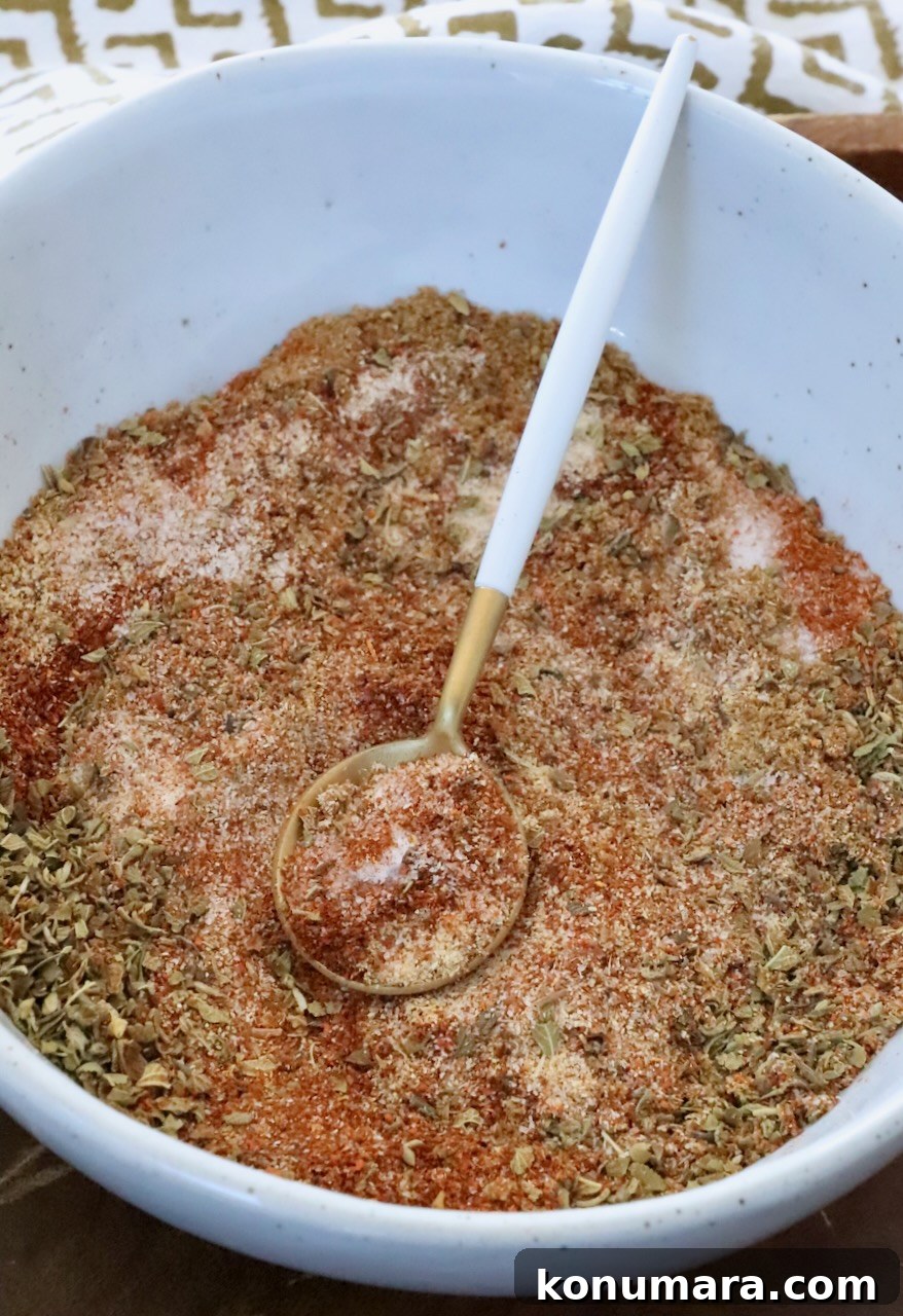 dried herbs and spices mixed together in a bowl with a spoon