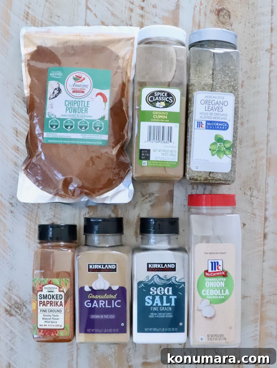 spices in plastic containers for chicken tacos seasoning lined up on a white wood table