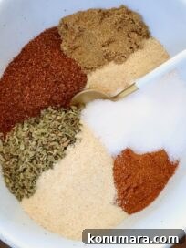 dried herbs and spices separated in a bowl with a spoon