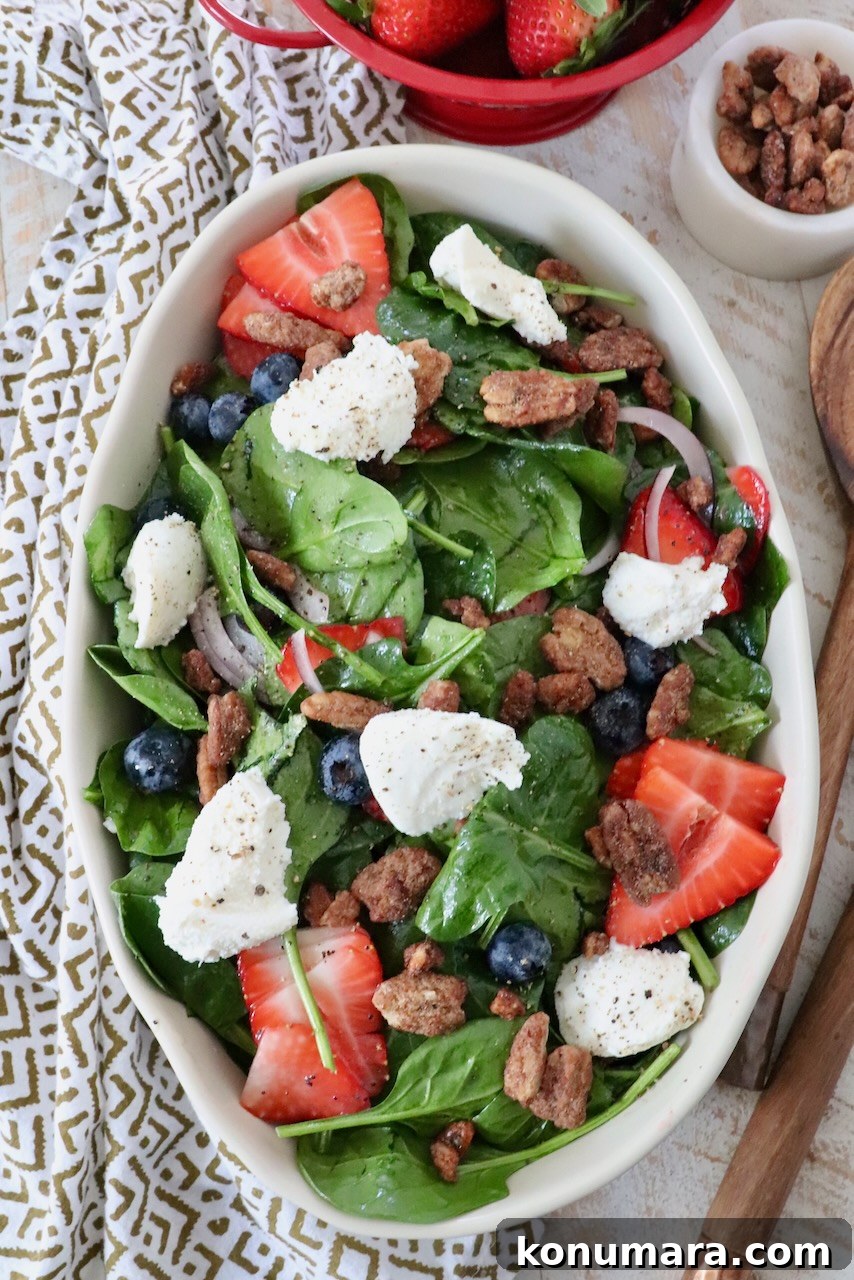 salad in large serving bowl topped with strawberries and ricotta cheese