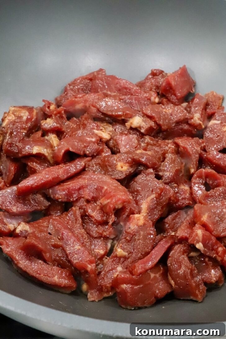 Korean Beef Bulgogi Lettuce Wraps Recipe 8 marinated strips of meat in a large wok on the stove