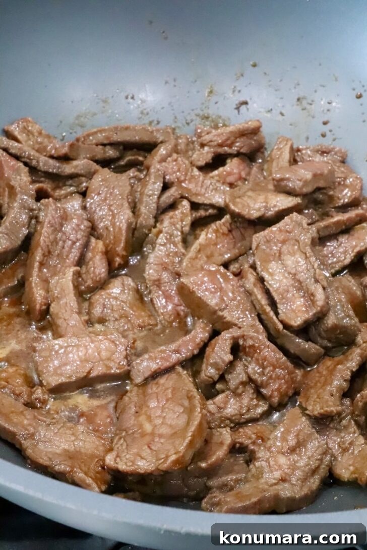 Korean Beef Bulgogi Lettuce Wraps Recipe 9 cooked strips of steak in a large wok on the stove in a Korean bbq sauce