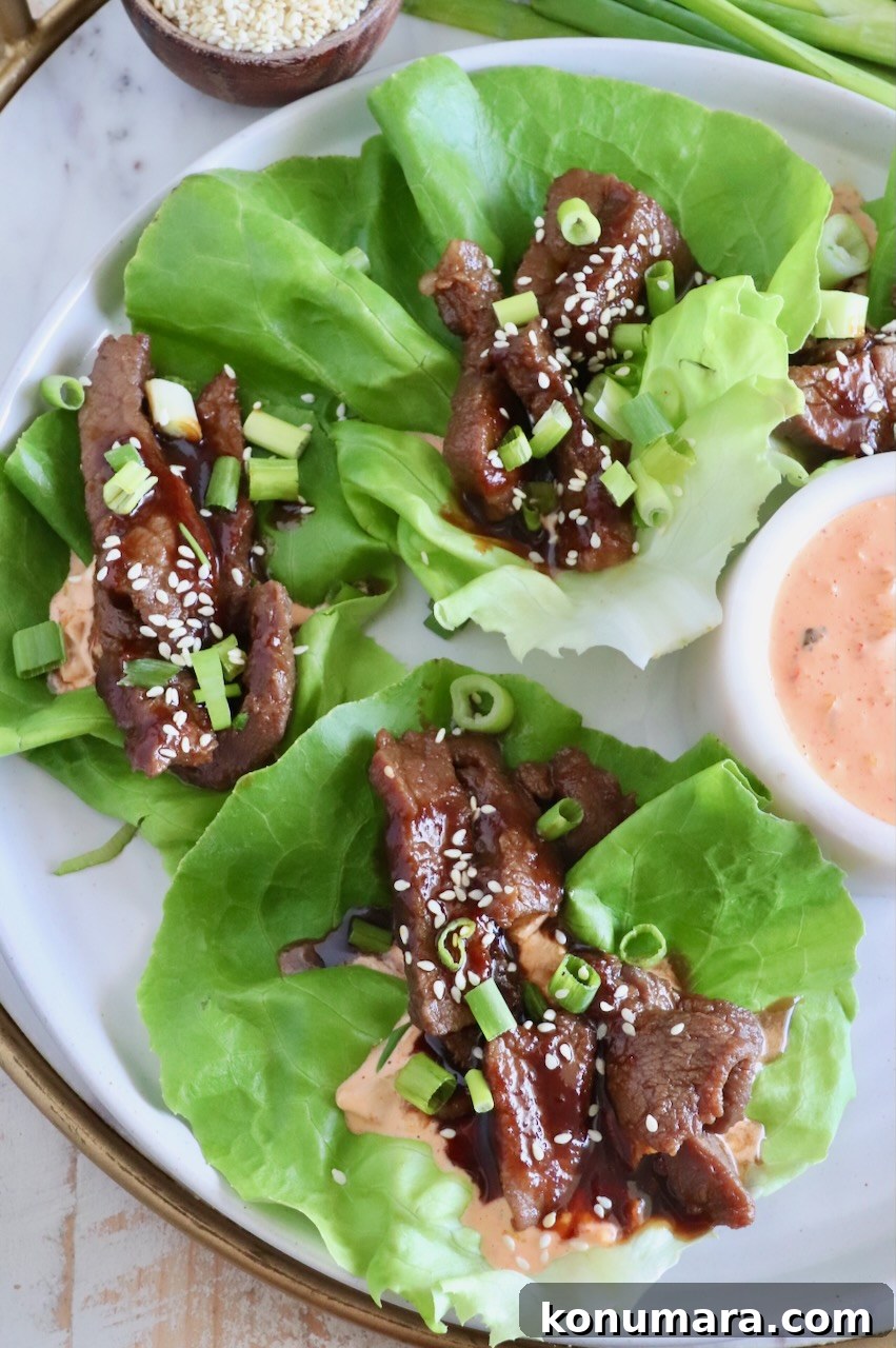 Korean Beef Bulgogi Lettuce Wraps Recipe 10 overhead image of Korean beef bulgogi in lettuce wraps with a creamy gochujang sauce on a plate