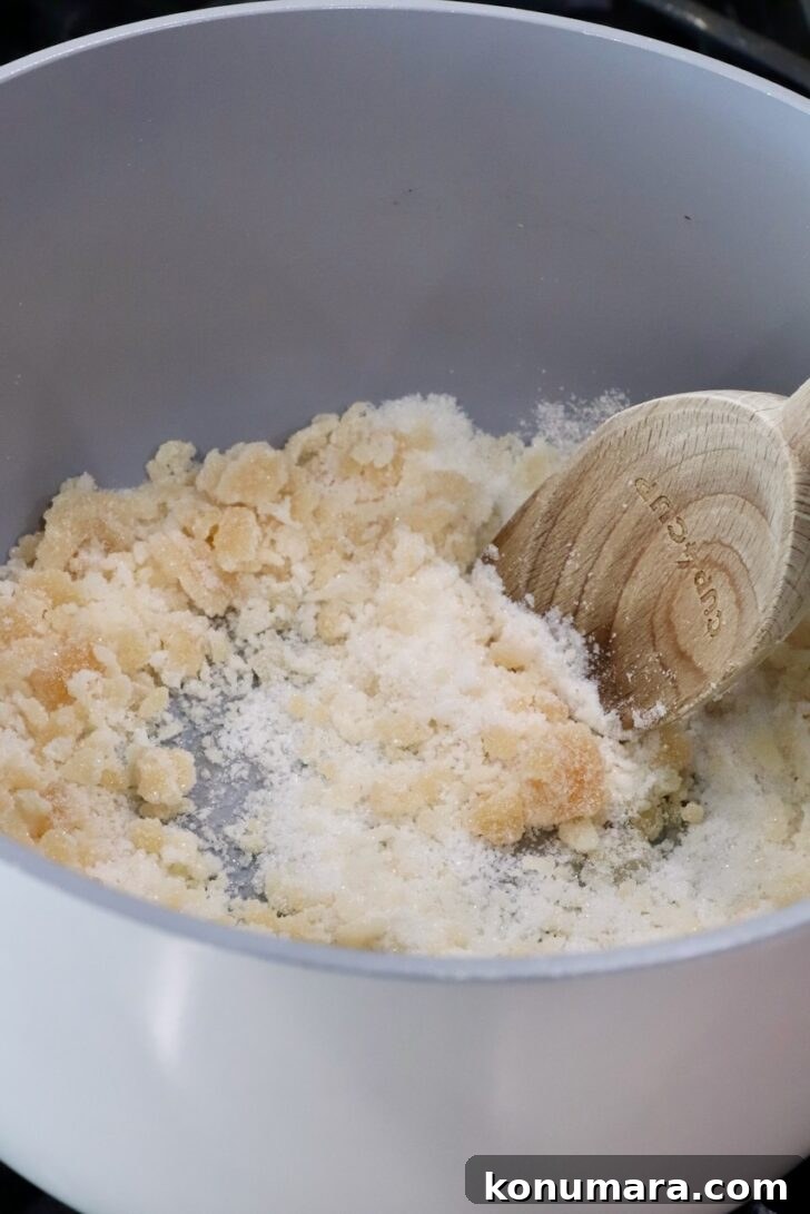 caramelizing sugar in a pot on the stove with a wooden spoon