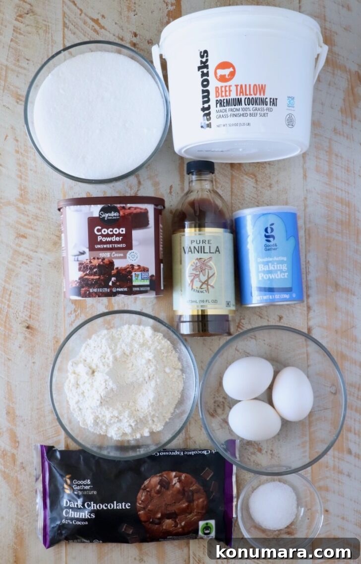 ingredients for beef tallow brownies on a white wood board