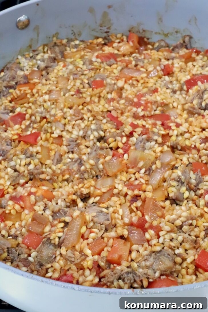 uncooked oxtail paella in a large skillet