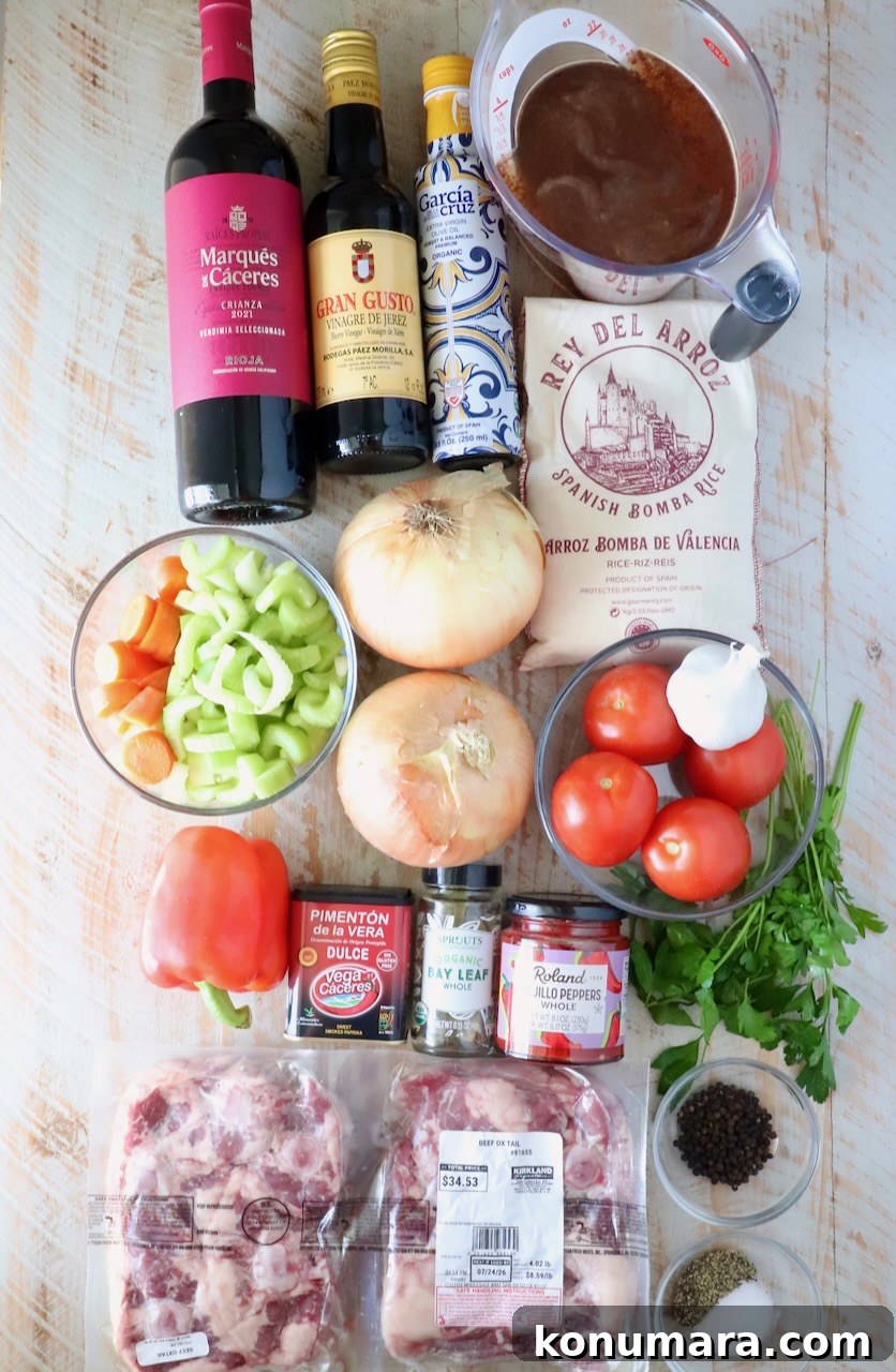 ingredients for braised oxtail paella on a white wood table