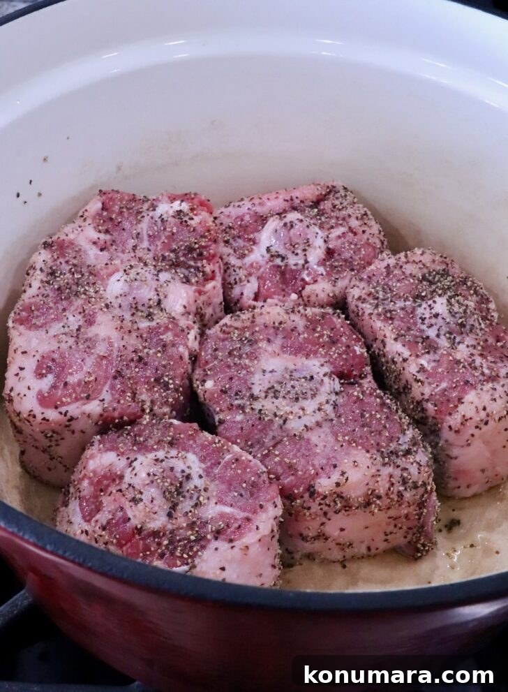 seasoned pieces of oxtail in a large cast iron pot