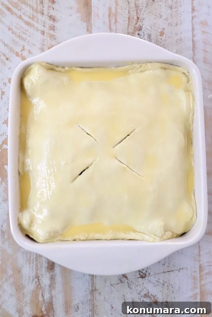 Braised Short Rib Pot Pie with French Onion 17 puff pastry dough, brushed with egg wash in a square baking dish