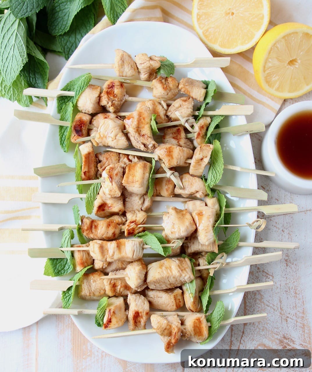 Grilled bourbon chicken on skewers with mint leaves