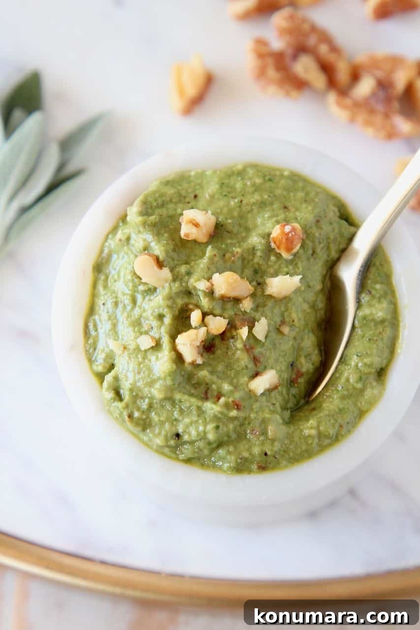 Sage pesto in bowl topped with chopped walnuts